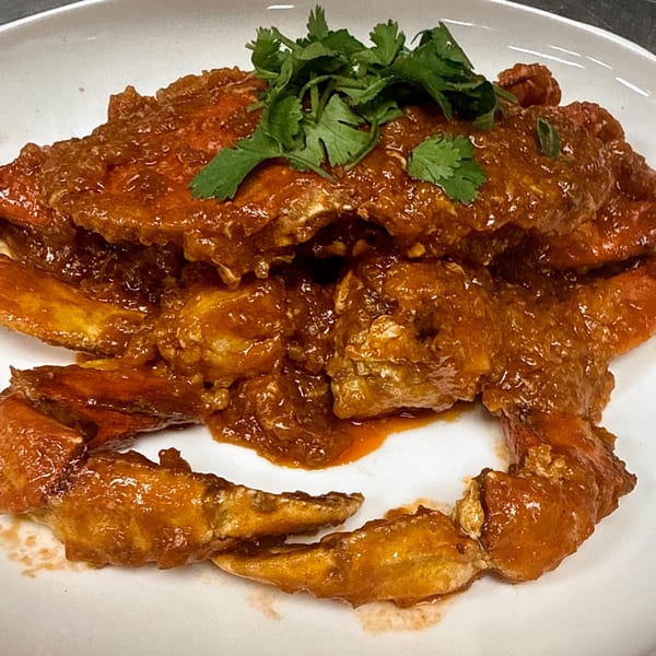 Chili crab from Gourmet Asian 888, covered in a rich, reddish-brown sauce and garnished with fresh cilantro.