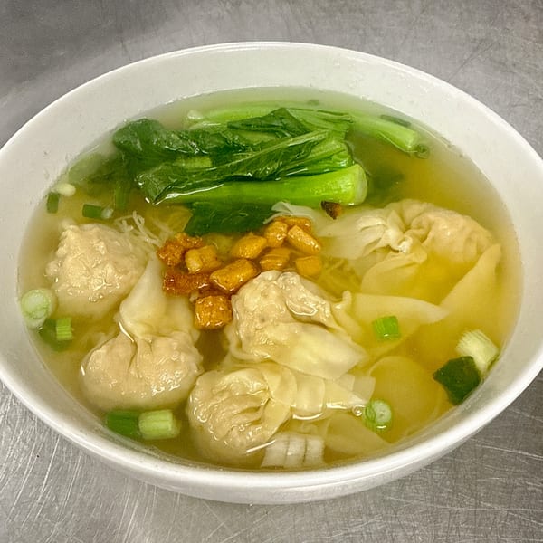 A bowl of Gourmet Asian 888 wonton soup with bok choy, fried garlic, and green onions.